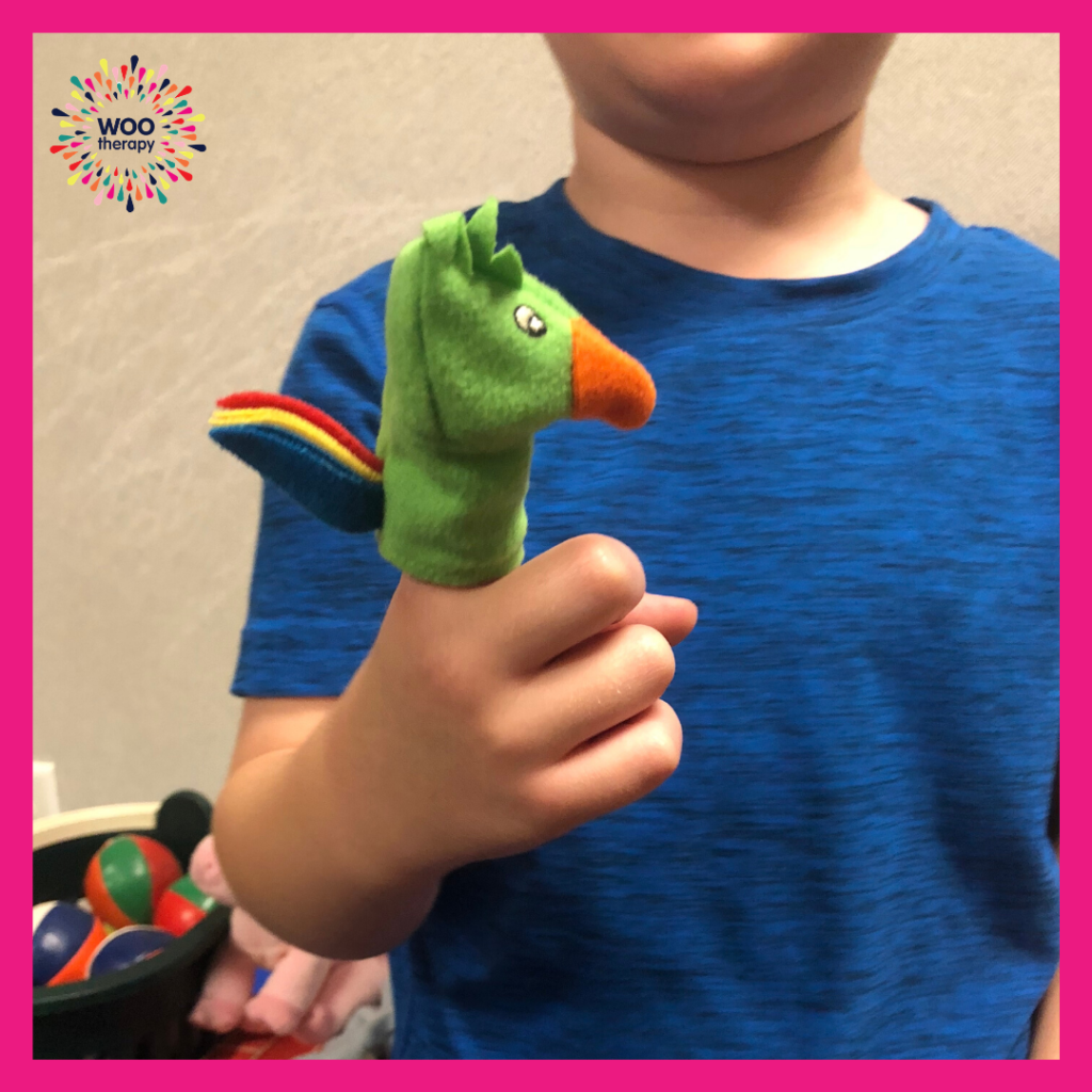 A child using his pointer finger to play with a finger puppet.